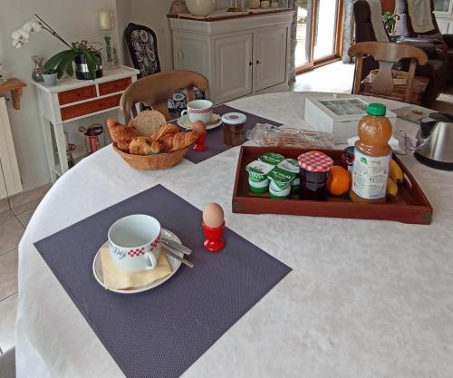 Liorzh an ty في Kerfany-les-Pins: طاولة مع كوب قهوة وصينية من الطعام