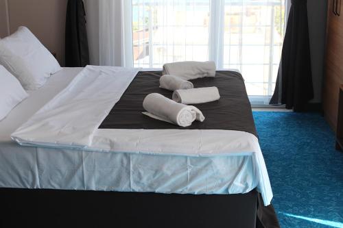 a bed with two towels on top of it at Silver Continent Hostel in Silivri