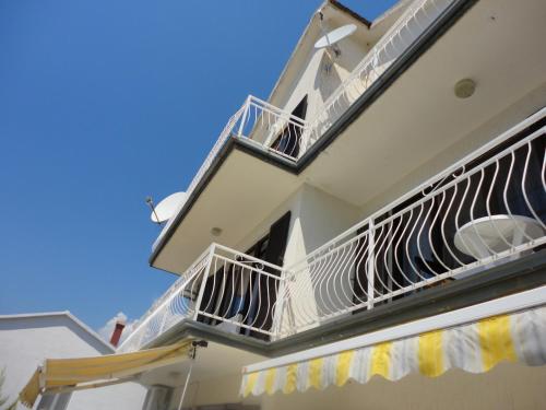 a white building with balconies and a blue sky at Wisteria in Tivat