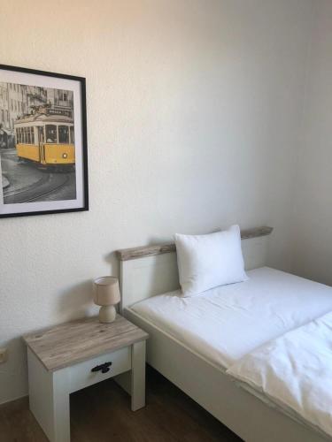 a bedroom with a bed and a table with a picture at Pension Highway Bünde Hansastraße in Bünde