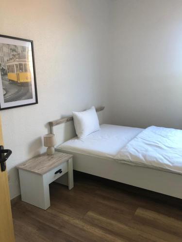 a small bedroom with a bed and a table at Pension Highway Bünde Hansastraße in Bünde