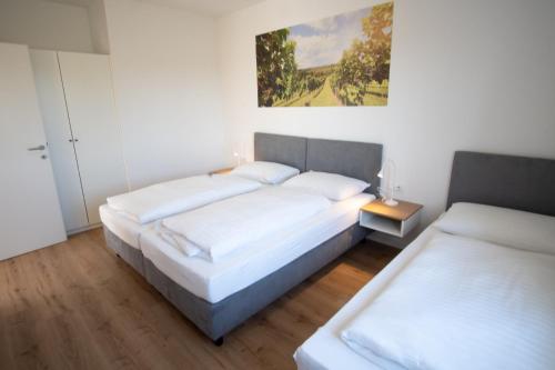 a bedroom with two beds and a painting on the wall at Family XL - Bungalows in Lutzmannsburg