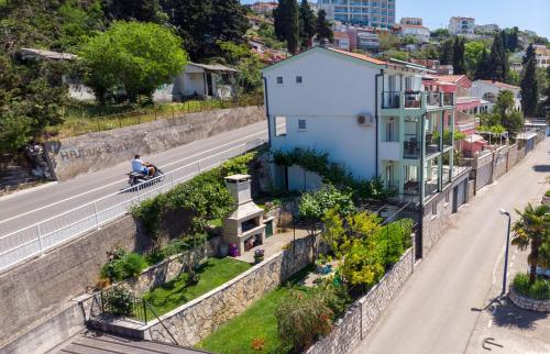a man riding a bike down a road next to a building at Apartments & rooms Leon in Neum