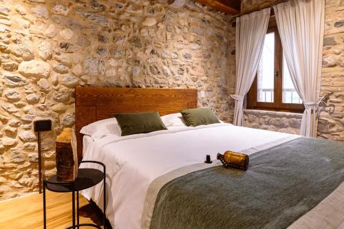 a bedroom with a large bed in a stone wall at Casa del Vicario in Fagagna