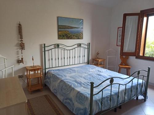 a bedroom with a bed with a blue comforter at Il giglio vista mare num iun Q6084 in Funtana Meiga