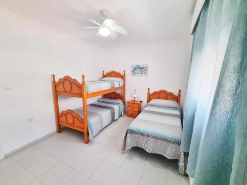 a bedroom with two bunk beds and a ceiling at Dunas y Luz in Rota