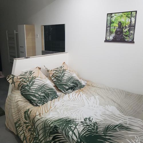 a bed with pillows and a picture on a wall at Appart 40m2 indépendant, confortable avec terasse in Lunel