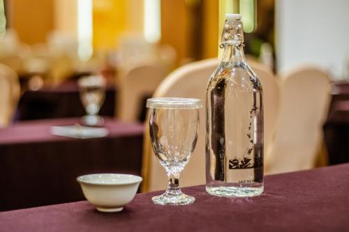 a bottle and glasses on a table with a bowl at Grand Tjokro Yogyakarta in Yogyakarta