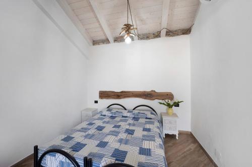 a bedroom with a bed with a blue and white comforter at Il Nido in Pompeiana