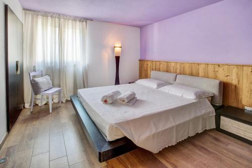 a bedroom with a large bed with two towels on it at La Maison du Bonheur Grosio in Grosio