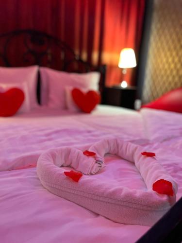 a bed with a heart shaped blanket on it at Hotel Corvin in Gyula