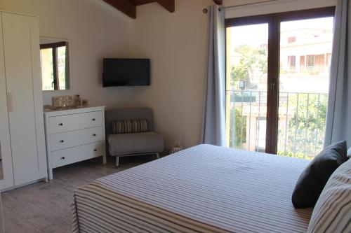 a bedroom with a bed and a dresser and a television at b&b U Punenti in La Maddalena