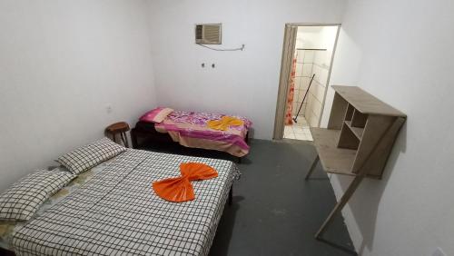 a small room with two beds and a mirror at Quitinetes Beira Rio in Canindé de São Francisco