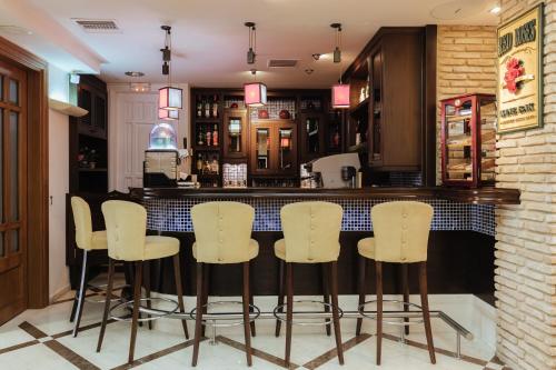 a bar with white bar stools in a restaurant at Akti Taygetos - Conference Resort in Kalamata