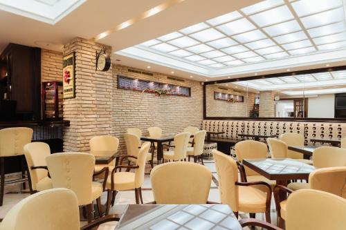 a restaurant with tables and chairs and a brick wall at Akti Taygetos - Conference Resort in Kalamata