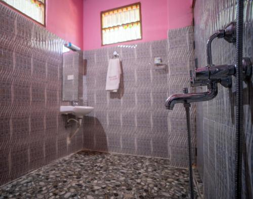 a bathroom with a shower with a sink and a toilet at Palm Grove Eco Resort in Port Blair