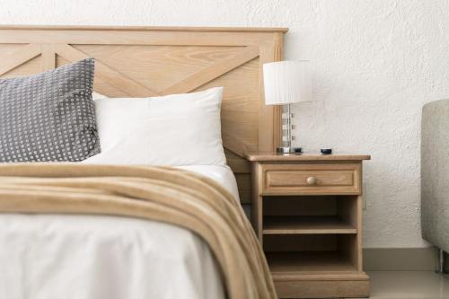 a bedroom with a bed and a nightstand with a lamp at Inn & Out Sandton Park in Johannesburg