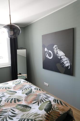 a bedroom with a bed with a picture on the wall at City-Apartment Die kleine Mü in Gmunden