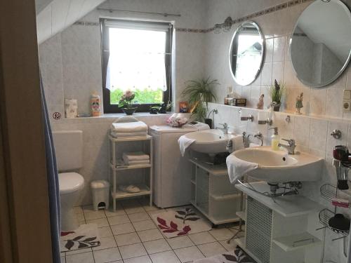 ein Badezimmer mit zwei Waschbecken, einem WC und einem Spiegel in der Unterkunft Haus Irena  in Longkamp