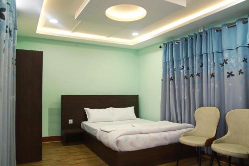 a small bedroom with a bed and two chairs at Kathway Hostel & Homestay in Kathmandu