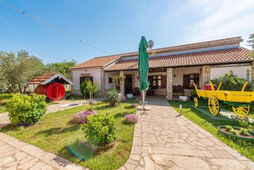 a house with a yellow wagon in the yard at Villa Štrkalj ZadarVillas in Murvica