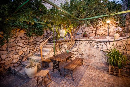 a patio with two benches and a stone wall at The Nest - A Romantic Vacation Home in Ein Kerem - Jerusalem in Jerusalem
