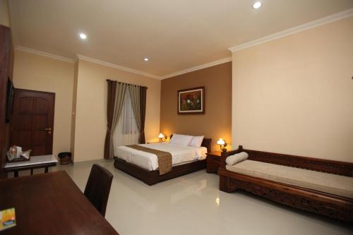 una camera d'albergo con due letti e un tavolo di Griya Yunika a Yogyakarta