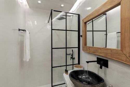 a bathroom with a sink and a mirror at Kaleidoscope Imerovigli Suites in Imerovigli