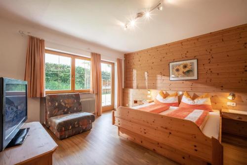 a bedroom with a bed and a tv in a room at Ferienwohnungen Salvenmoser Johanna in Scheffau am Wilden Kaiser
