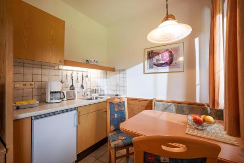 a kitchen with a wooden table and a table and a table and a table at Ferienwohnungen Salvenmoser Johanna in Scheffau am Wilden Kaiser
