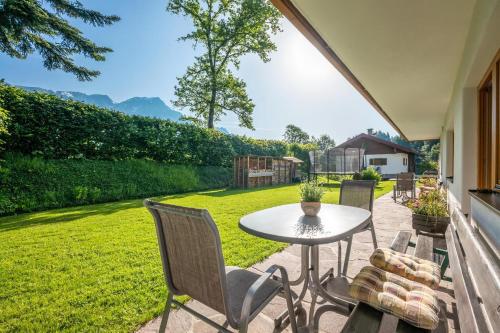 a patio with a table and chairs and a yard at Ferienwohnungen Salvenmoser Johanna in Scheffau am Wilden Kaiser