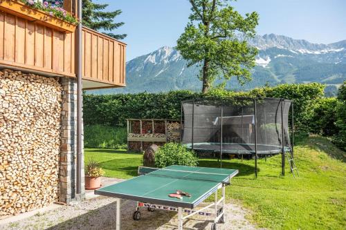 a ping pong table in the backyard of a house at Ferienwohnungen Salvenmoser Johanna in Scheffau am Wilden Kaiser