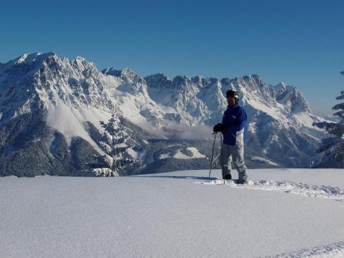 a man standing on top of a snow covered mountain at Ferienwohnungen Salvenmoser Johanna in Scheffau am Wilden Kaiser