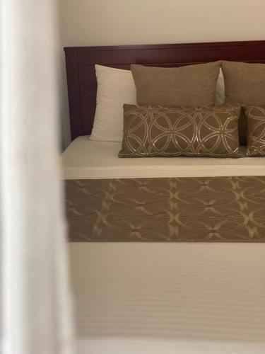 a bed with brown and white pillows on it at Villa Crystals in Colombo