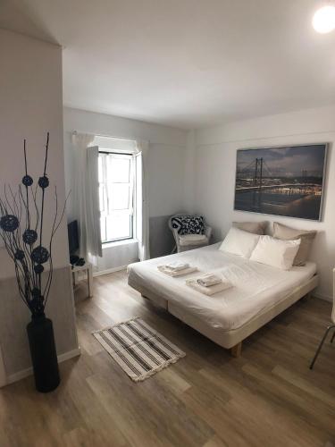 a bedroom with a bed and a vase of flowers at LX Lisboa Cozy studio in Lisbon