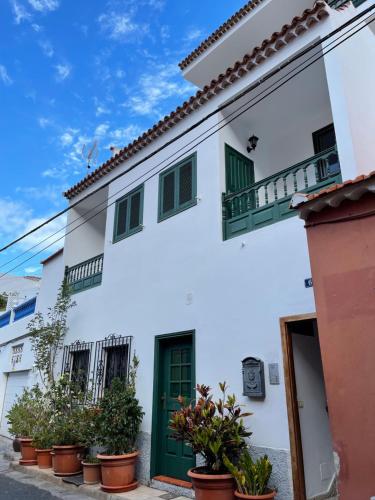 Casa blanca con puertas verdes y macetas en Vivienda Turística Juliana en Valle Gran Rey