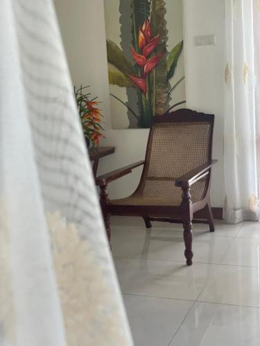 a chair sitting in a room with a painting on the wall at Villa Crystals in Colombo