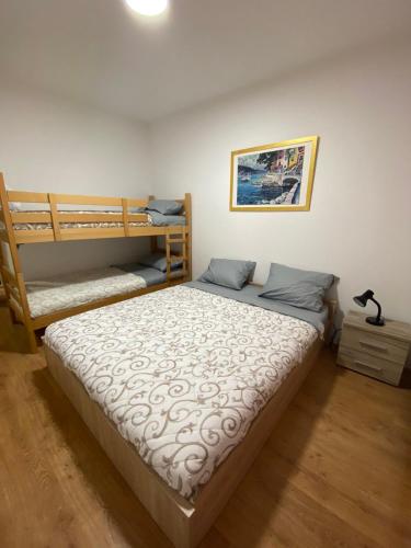 a bedroom with a bed and two bunk beds at Apartman Kasija in Jagodina