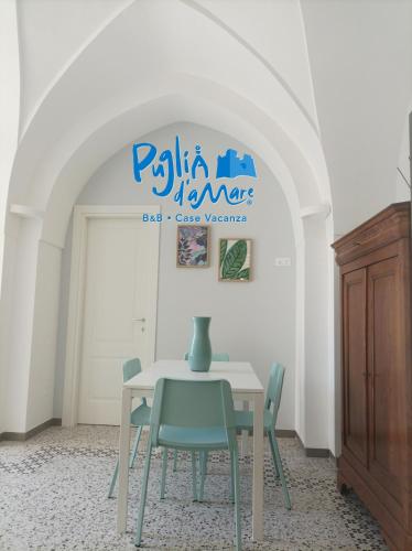 a table with chairs and a vase on top of it at Puglia d'aMare Casa Vacanza in Lizzano