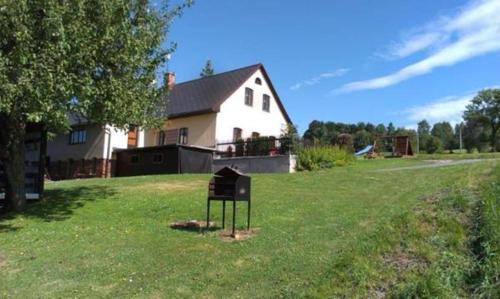 a sign in the grass in front of a house at Chalupa u Vyšanských in Jilemnice