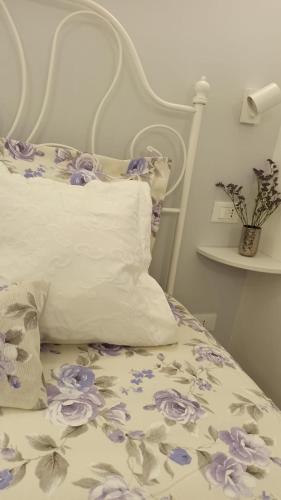 a bed with a floral bedspread and a pillow at Puglia d'aMare Casa Vacanza in Lizzano