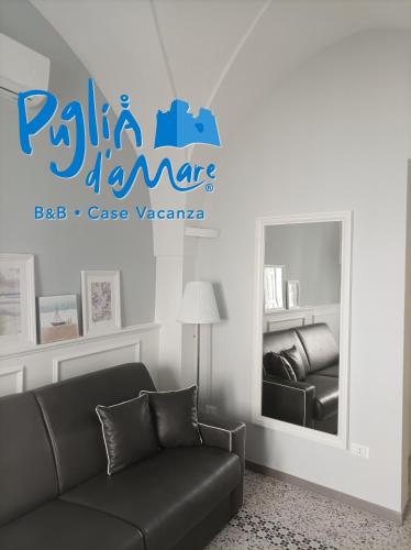 a living room with a couch and a mirror at Puglia d'aMare Casa Vacanza in Lizzano