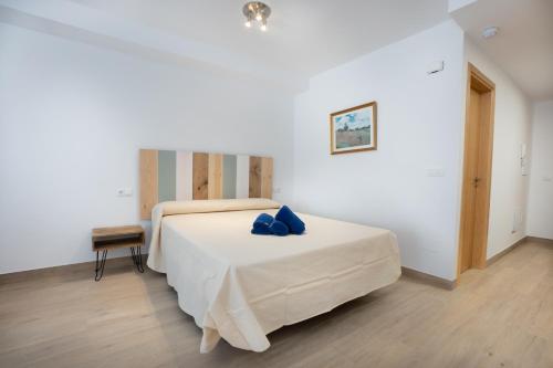 a bedroom with a bed with blue pillows on it at A&F Apartments in Nerja