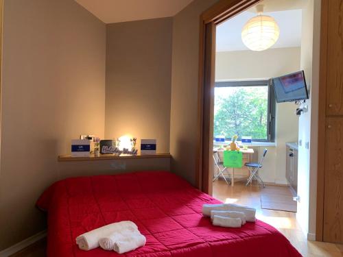- une chambre avec un lit rouge et 2 serviettes dans l'établissement House Marittima by Holiday World, à Gênes