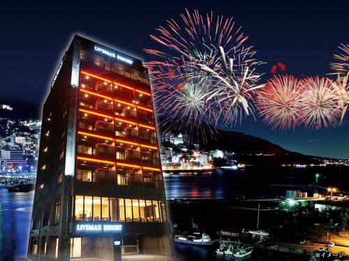 a hotel with fireworks in the background with a building at LiVEMAX RESORT Atami Sea Front in Atami
