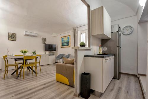 a kitchen and a living room with a table at MACHIN 57 - Magnolia Holidays in Alghero