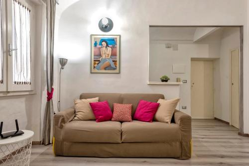 a living room with a brown couch with pink pillows at MACHIN 57 - Magnolia Holidays in Alghero