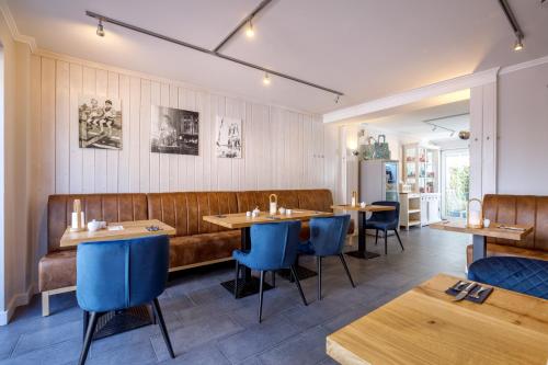 a restaurant with wooden tables and blue chairs at Logierhaus RheintorEins in Rees