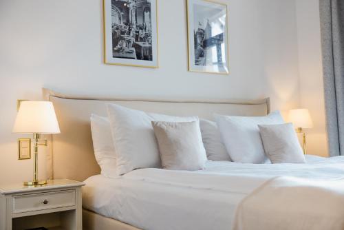 a bedroom with a white bed with white pillows at Le Mirador Resort & Spa in Vevey