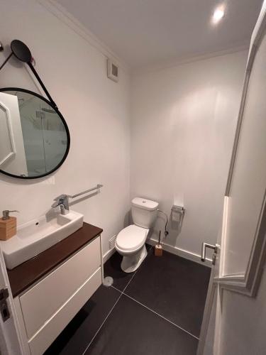 W łazience znajduje się toaleta, umywalka i lustro. w obiekcie Condomínio Del Rey w mieście Charneca